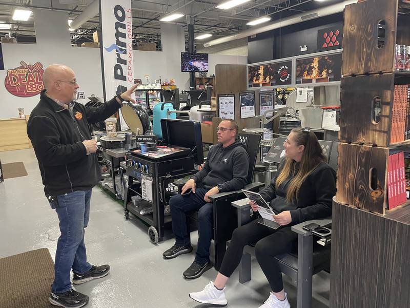 Smokin' Deal BBQ owner Jeff Silvers talks with customers Mike Huber and Melissa Lucich of Palatine before the couple purchased a new Pit Boss griddle and accessories this month.
