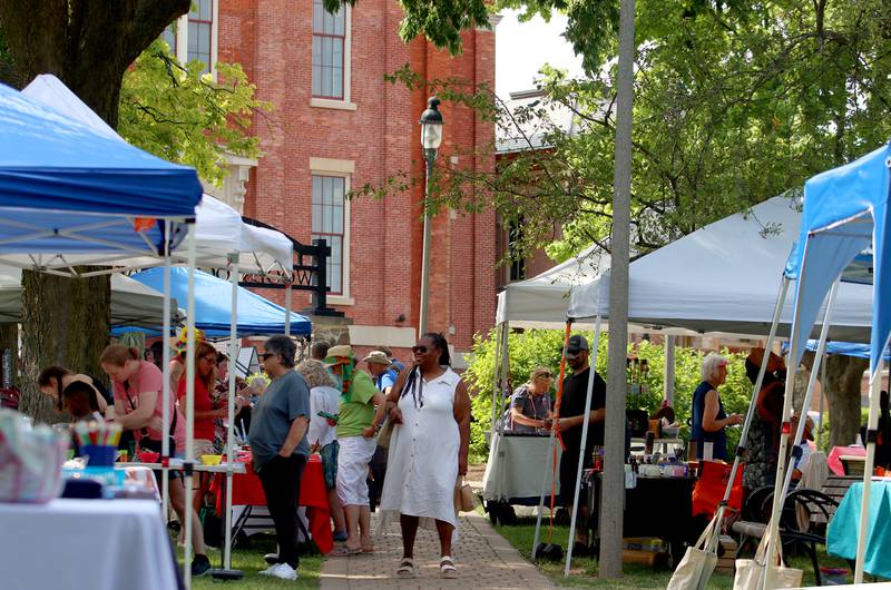 People meander through booths during McHenry County’s 2nd Annual Juneteenth Festival at the Woodstock Square Saturday.