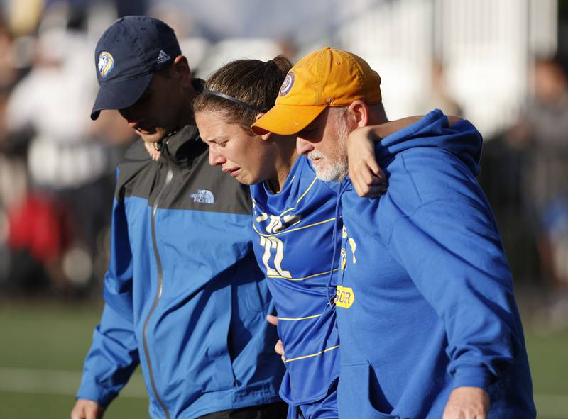 Lyons' Peyton Israel (22) is helped off the field after an injury during the Class 3A Dominican super-sectional between New Trier and Lyons Township in River Forest on Tuesday, May 28, 2024.