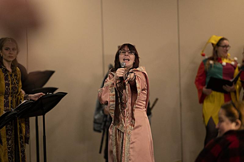 A Madrigal player acts out a scene Thursday, Dec. 21, 2023 during Dixon High School’s choir dinner.