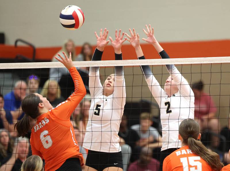 Sycamore's Kylie Walsh (left) and Madilyn Patton try to block the tip of DeKalb's Adisyn Galijatovic during their match Wednesday, Aug. 28, 2024, at DeKalb High School.