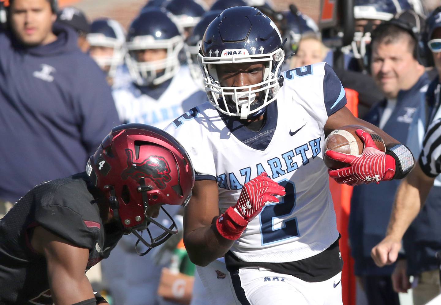 Nazareth's Justin Taylor picks up big yardage before being knocked out of bounds by Peoria's Ricky Hearn during their IHSA Class 5A state championship game Saturday, Nov. 26, 2022, in Memorial Stadium at the University of Illinois in Champaign.