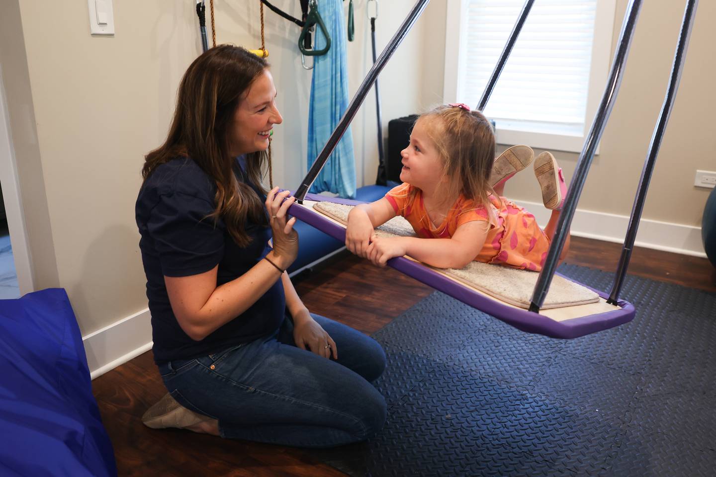 Maggie Ruzich plays with her daughter, Joey 4-years-old, on a therapy swing that helps young clients develop balance skills on Tuesday, August 20, 2024 in Plainfield.