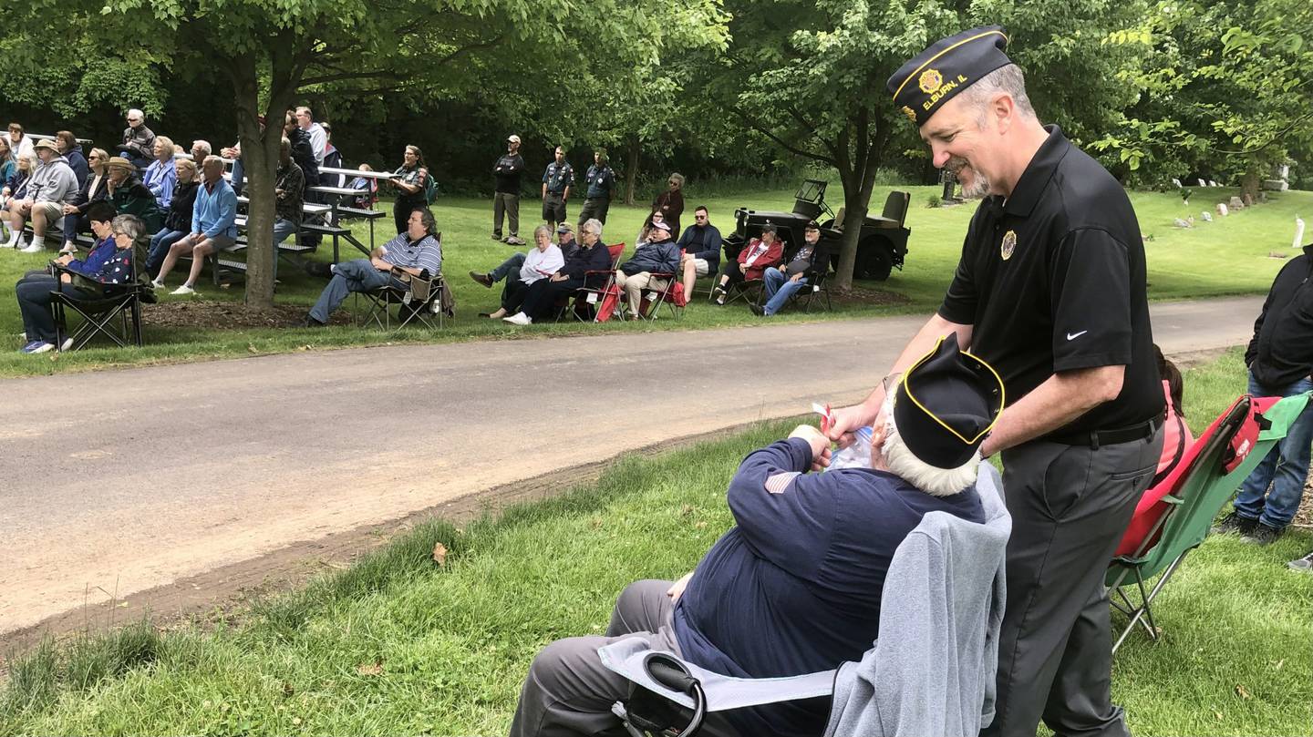 Elburn American Legion Senior Vice Commander John Nevenhoven (Right) hands out poppies to attendees of the Memorial Day ceremony in Blackberry Township Cemetery.