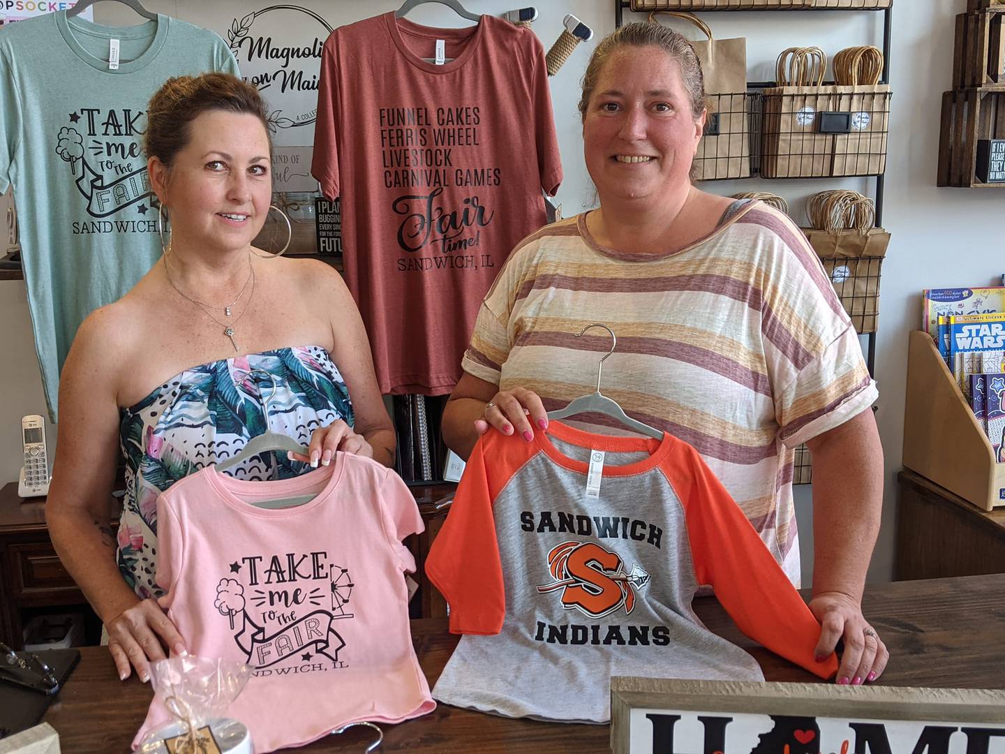 Nancy Discher, left, and Magnolia On Main owner Tracy Merovci, right, show some of the Sandwich-related items available at the store.