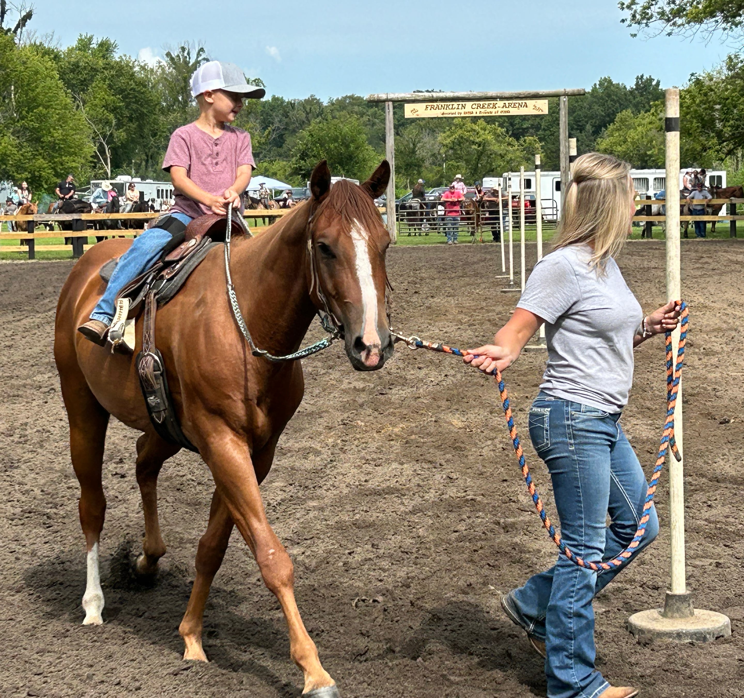 Callie Johnson of Rochelle guides her son, Ty, 5, and his horse Lucky through the Poles Competition at the Rock River Trail & Horseman Association's Grand Opening Show on Saturday, July 20, 2024.