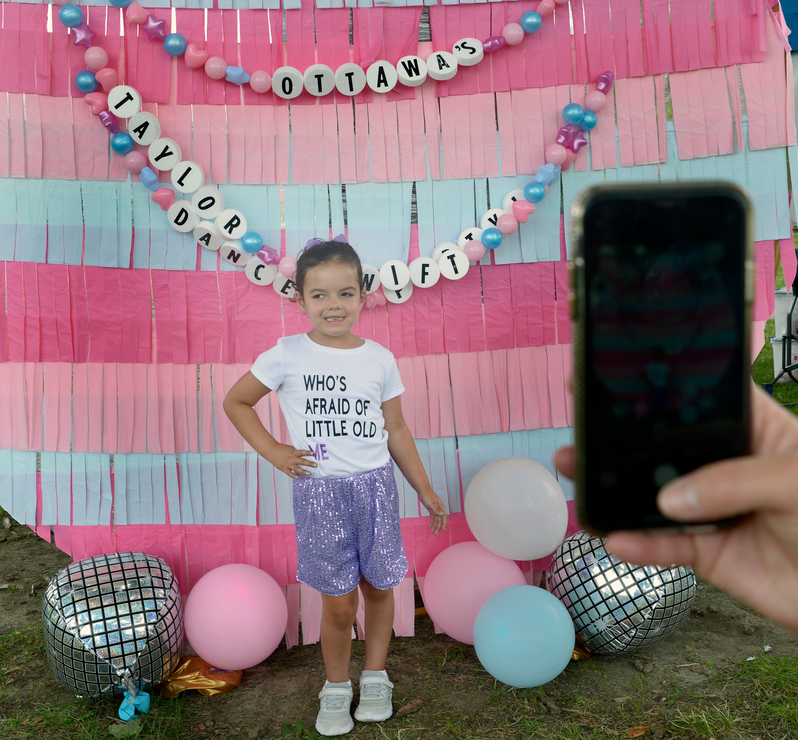 Everly Bruck has her photo taken at a Taylor Swift display Sunday during the Taylor Swift Dance Party in Ottawa. The event was part of Friendship Days.