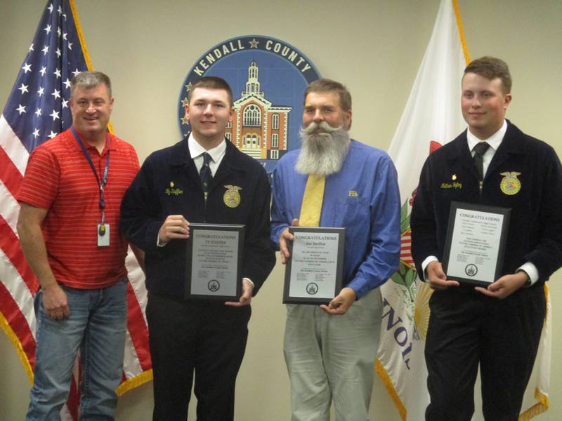 Kendall County Board Chairman Matt Kellogg, from left, presented awards for the Newark High School Future Farmers of America program to Ty Steffen, Joe Steffen and Nate Toftoy on Oct. 3.