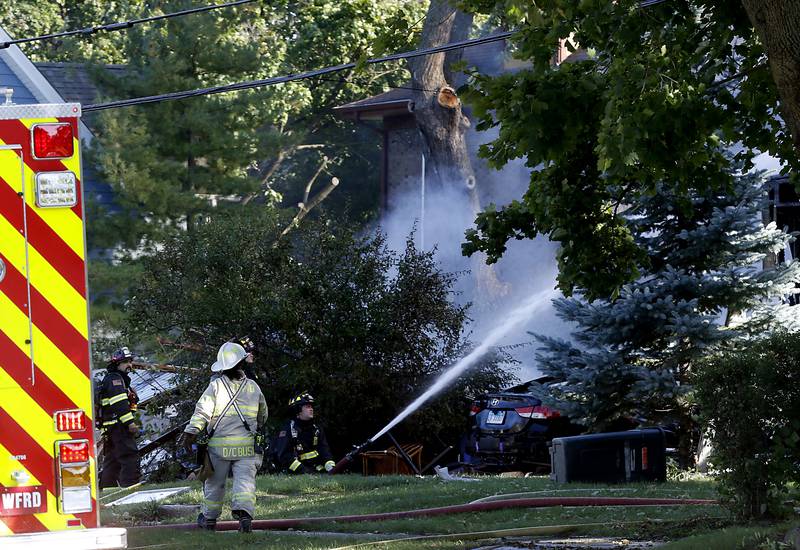 Firefighters battle a house fire in the 300 block of Lincoln Avenue in Woodstock Monday, Oct. 9, 2023, after an explosion following suspected gas leak in the area.