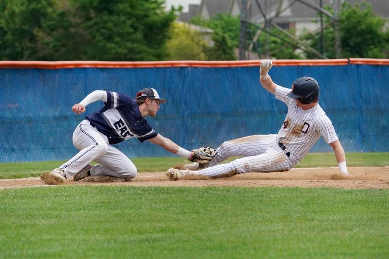 Oswego East's Christian Martyn (30) tags Oswego’s Patrick OToole (4) for an out at third base during a baseball game at Oswego High School on Monday, May 13, 2024.