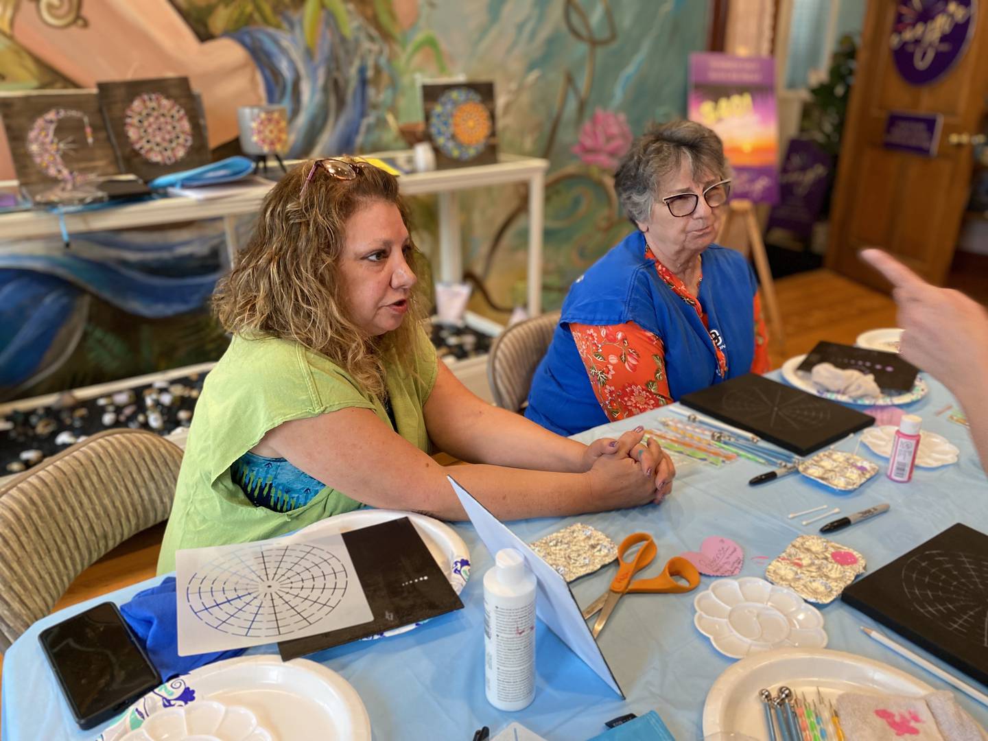 Angel Staub (on the left) hosts Mandala Painting Event on Sunday, June 4, during the grand-opening of Energie Salt Studio Spirit and assists Linda Williams (on the right).