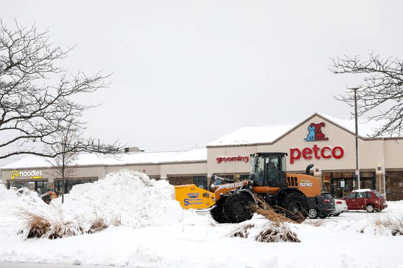 Snow is cleared from a parking lot in Wheaton following several more inches of snowfall in DuPage County on Friday, Jan. 12, 2024.