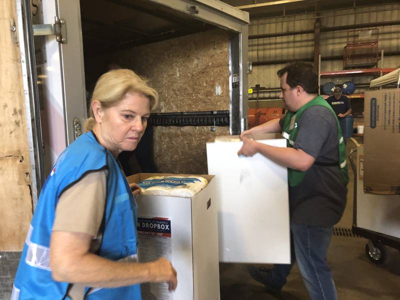 Arlene Ryndak of the McHenry County Medical Reserve Corps and Matthew Robertson load a trailer with supplies at Operation Dropbox June 11, 2024.
