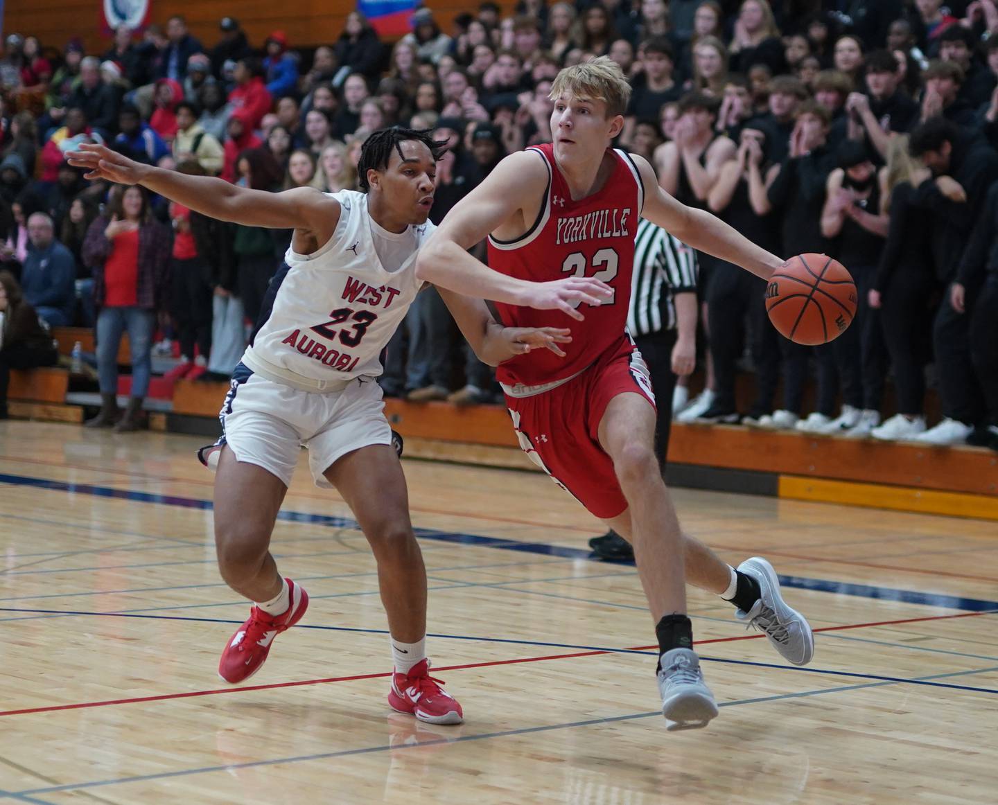 Yorkville's Jason Jakstys (32) drives to the basket against West Aurora's Evan Hackney (23) during a basketball game at West Aurora High School on Tuesday, Nov 28, 2023.