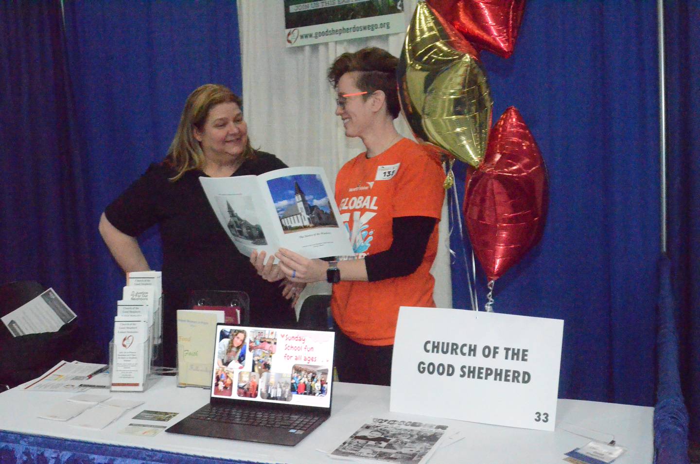 Oswego residents Jessie Livingston, left, and Rachel Conover view Church of the Good Shepherd United Methodist’s ”The Story of the Windows”  booklet Saturday at Oswego Hometown Expo at Oswego High. To be released March 3, the 29-page  booklet chronicles 23 historic stained-glass windows mounted in the Oswego church’s 128-year history.