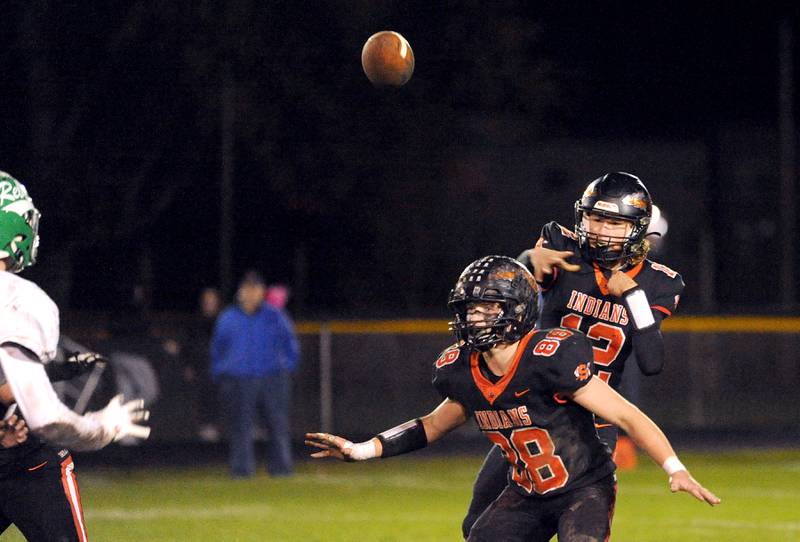 With protection from Jeffrey Ashley (88), quarterback Brady Behringer (12) tosses a pass against Ridgewood during a varsity football game at Sandwich High School on Friday, Oct. 27, 2023.