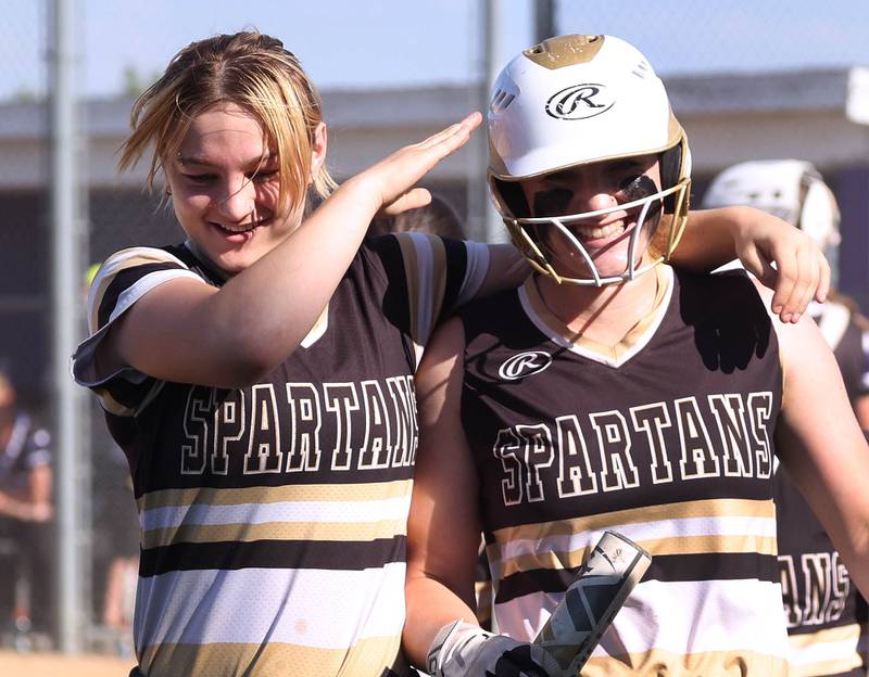 Sycamore's Ellison Hallahan (right) is congratulated by a teammate after hitting a grand slam during their Class 3A regional final against Dixon Thursday, May 23, 2024, at Rochelle High School.