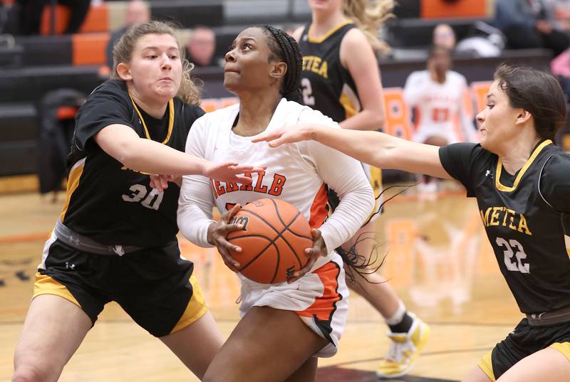 DeKalb’s Cayla Evans splits two Metea Valley defenders during their game Friday, Jan. 19, 2024, at DeKalb High School.