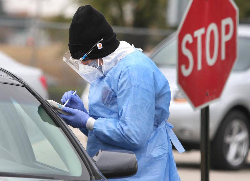 Phlebotomists Meghan O'Rorke takes information from a patron prior to collecting a sample during free drive-thru COVID-19 testing at Sycamore High School Tuesday afternoon. The testing at this site by HR Support is offered through a partnership with the Illinois Department of Public Health, the DeKalb County Health Department and Sycamore School District 427.