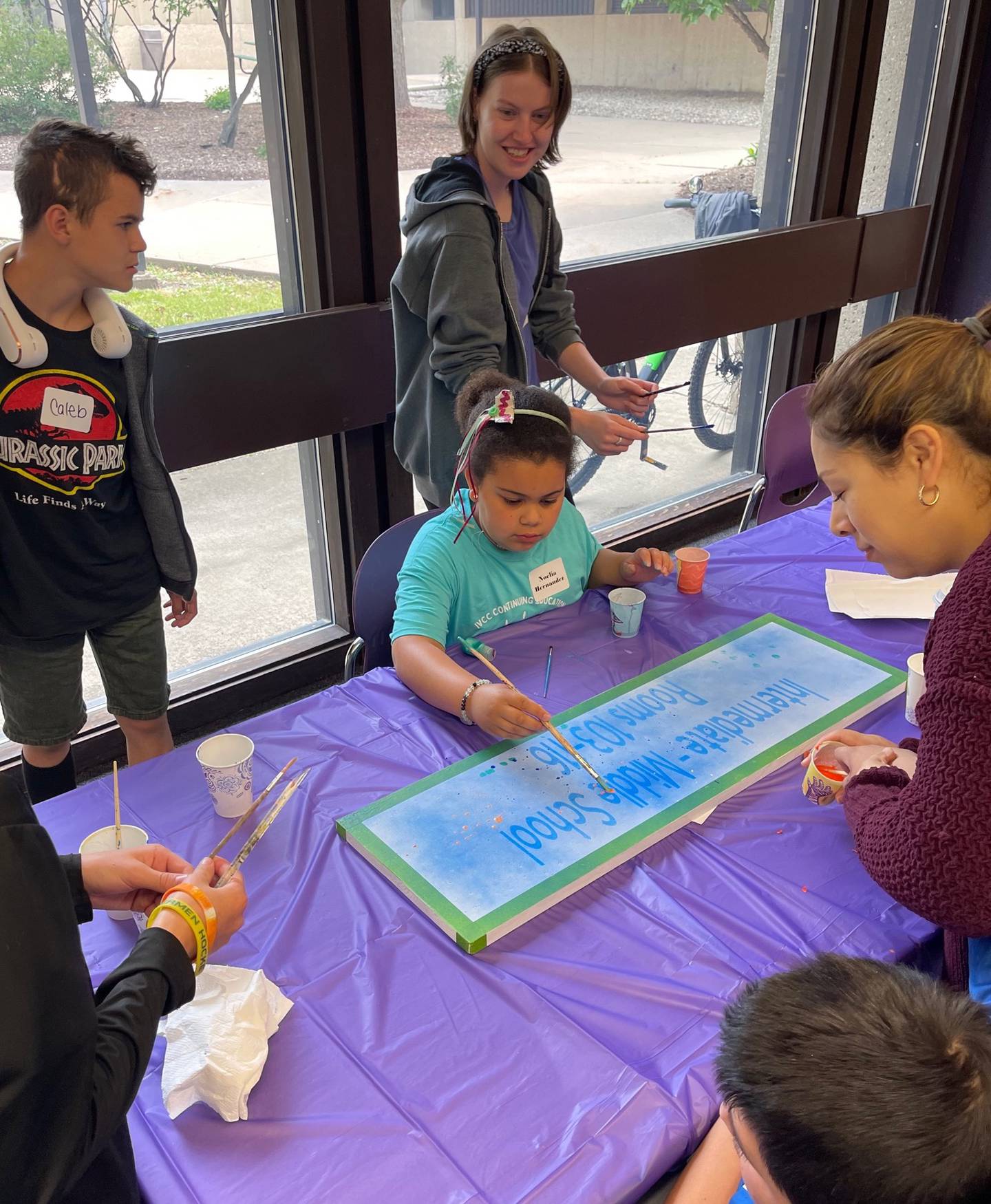 Noelia Herandez, a participant in the Camp Kindness program at Illinois Valley Community College for ages 9-12, creates a splatter paint hallway sign for the new Lighted Way School building in La Salle. Camp Kindness was led by Jyllina Ossola and assisted by Grace Krizel.