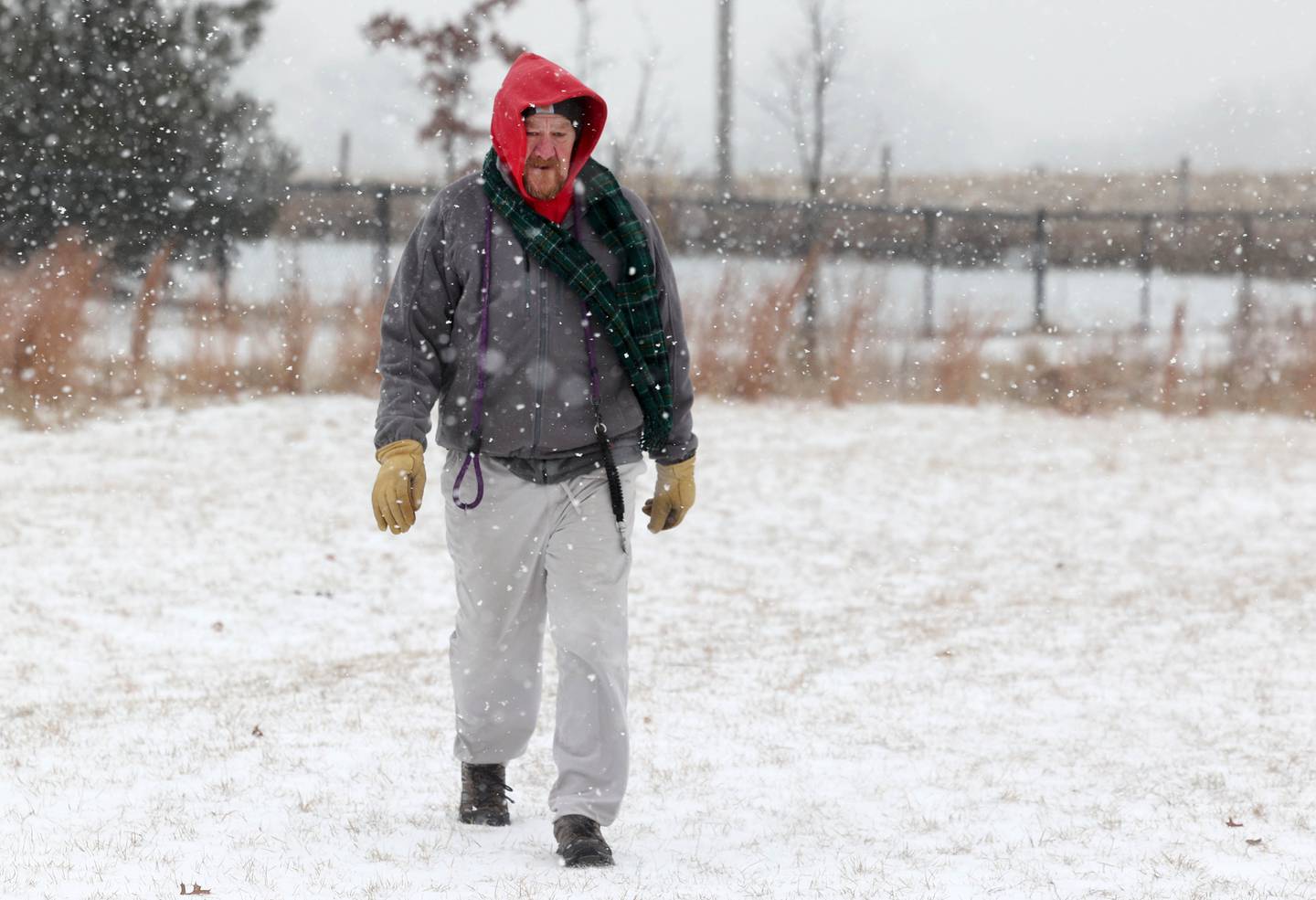 Joel Plapp, of Sycamore, tries to stay warm as he watches his dog Gracie Thursday, Dec. 22, 2022, at the Sycamore Park District Dog Park. Snow, frigid temperatures and wind rolled into the area Thursday making travel and any outdoor activity a challenge.