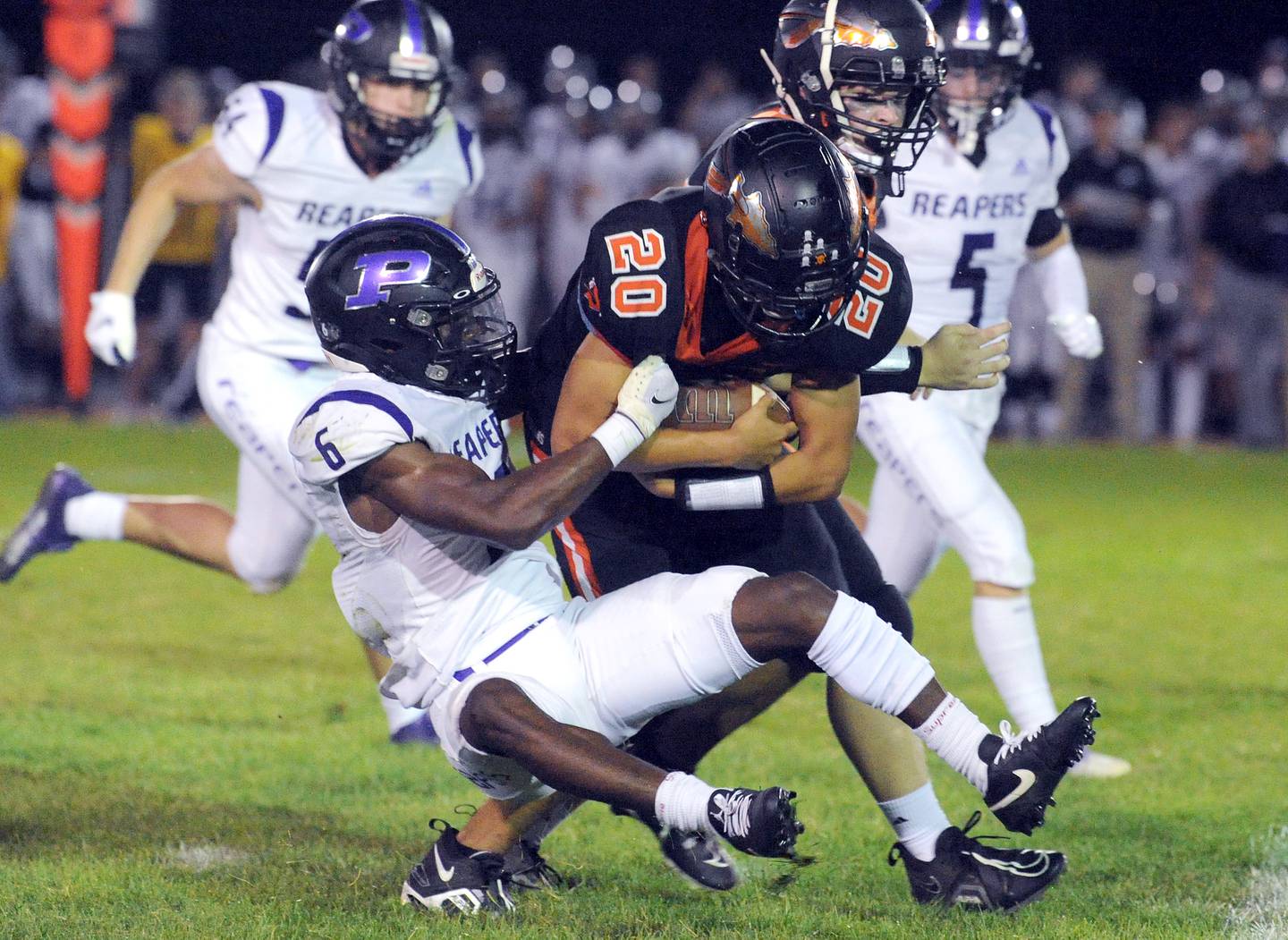 Plano defender Waleed Johnson (6) wraps up Sandwich running back Diego Gomez (20) in the Route 34 rivals' game last season at Sandwich High School.