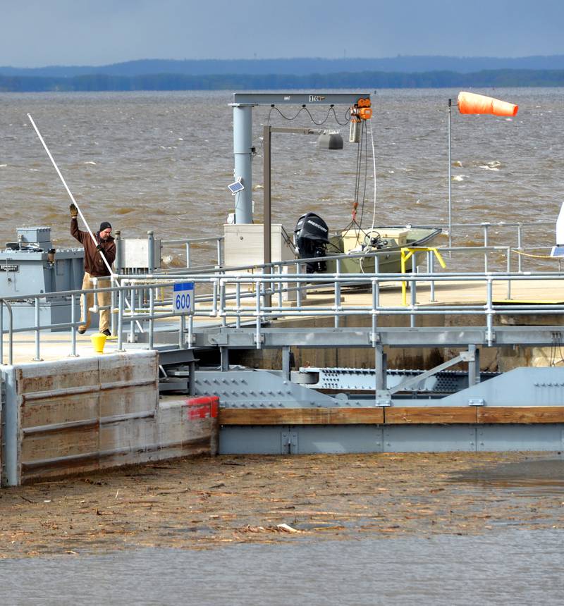 A worker at Lock & Dam 13, between Thomson and Fulton, uses a long metal rod to push debris away from the north end of the lock on Saturday, April 22. Mississippi River levels were expected to continue to rise and possibly crest at 22' this week.
