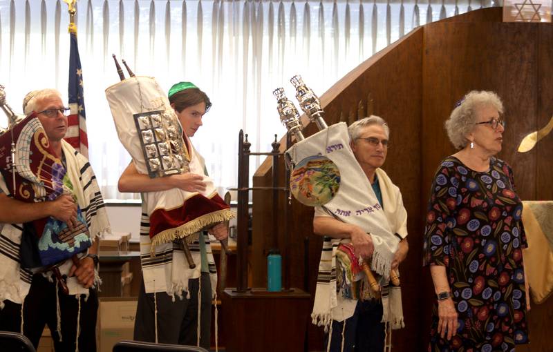 Torah Scrolls are marched from the building as the McHenry County Jewish Congregation held a deconsecration ceremony at their Ridgefield Road location in preparation for a move to the Tree of Life Unitarian Church in McHenry on Sunday, August 18. Mezuzot were removed from doorways and the Torah Scrolls were removed from their ark and transported  to the new building as worshipers consecrated the new building as their synagogue.