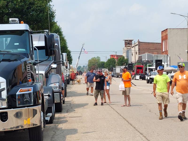 Visitors walk down Main Street in Ladd checking out dozens of large vehicles Saturday, July 15, 2023, during the Convoy Against Cancer BIG Truck Show.