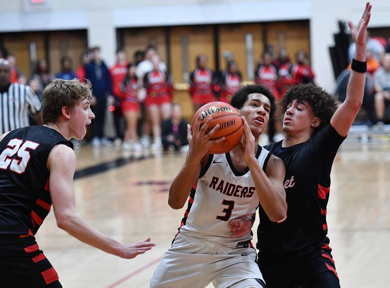 Bolingbrook's Davion Thompson (3) goes to the basket between Benet defenders Gabe Sularski (25) and Jayden Wright during a Class 4A East Aurora Sectional semifinal game on Feb. 27, 2024 at East Aurora High School in Aurora.