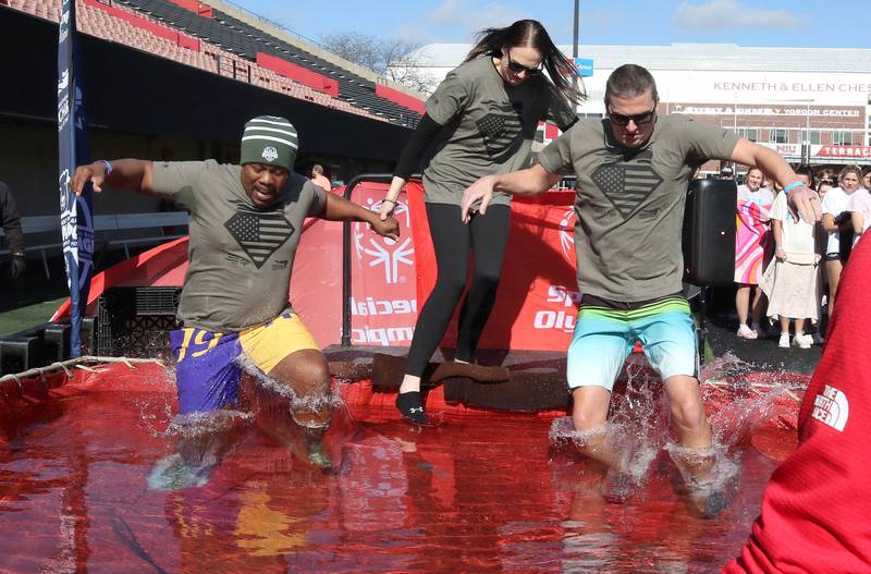 Representatives from the Sycamore Police Department jump into the water on a cold and windy Saturday, Feb 17, 2024, during the Huskie Stadium Polar Plunge at Northern Illinois University in DeKalb. The Polar Plunge is the signature fundraiser for Special Olympics Illinois.