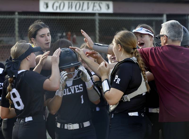 Prairie Ridge’s Emily Harlow is congratulated by her teammates after she hit a home run during a Fox Valley Conference softball game against Huntley on Monday, April 29, 2024, at Prairie Ridge High School.