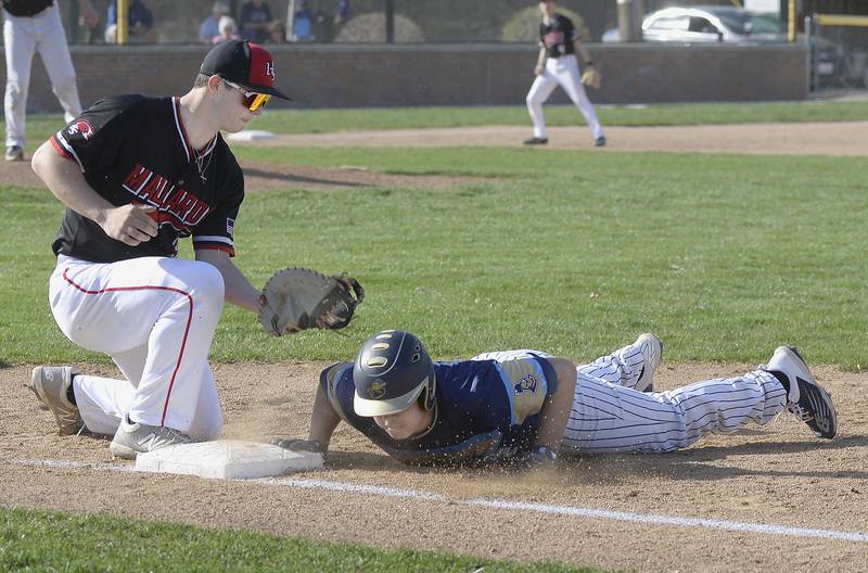 Marquette’s Sam Mitre dives into 1st base ahead of the tag by Henry-Senachwine’s Lance Kiesewtter on a pickoff attempt