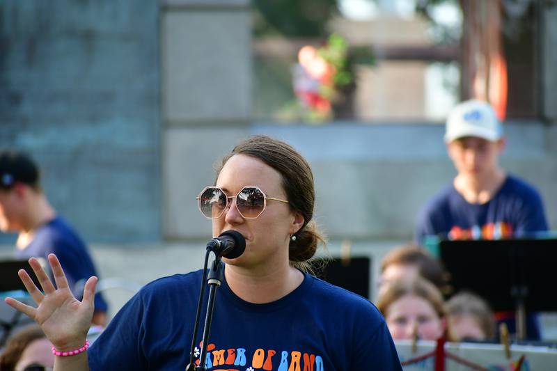 Megan Olson explains to the audience Sunday, July 14, 2024, some interesting facts about the next song during the youth band concert in Princeton.