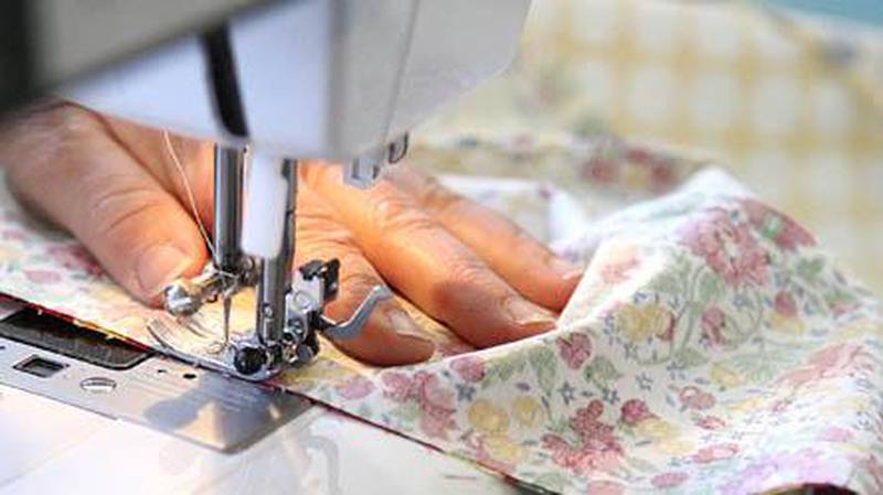 Carolyn McQuillan sews strips of fabric together while making a ruffled "Trixie" bag as a sample for her Clare quilt shop, Basketcases Unlimited. According to McQuillan, customers and workshop participants enjoy the traditional crafts of quilting and sewing and use the art to escape the rush of everyday life. KATE WEBER CARLSON | kcarlson@daily-chronicle.com