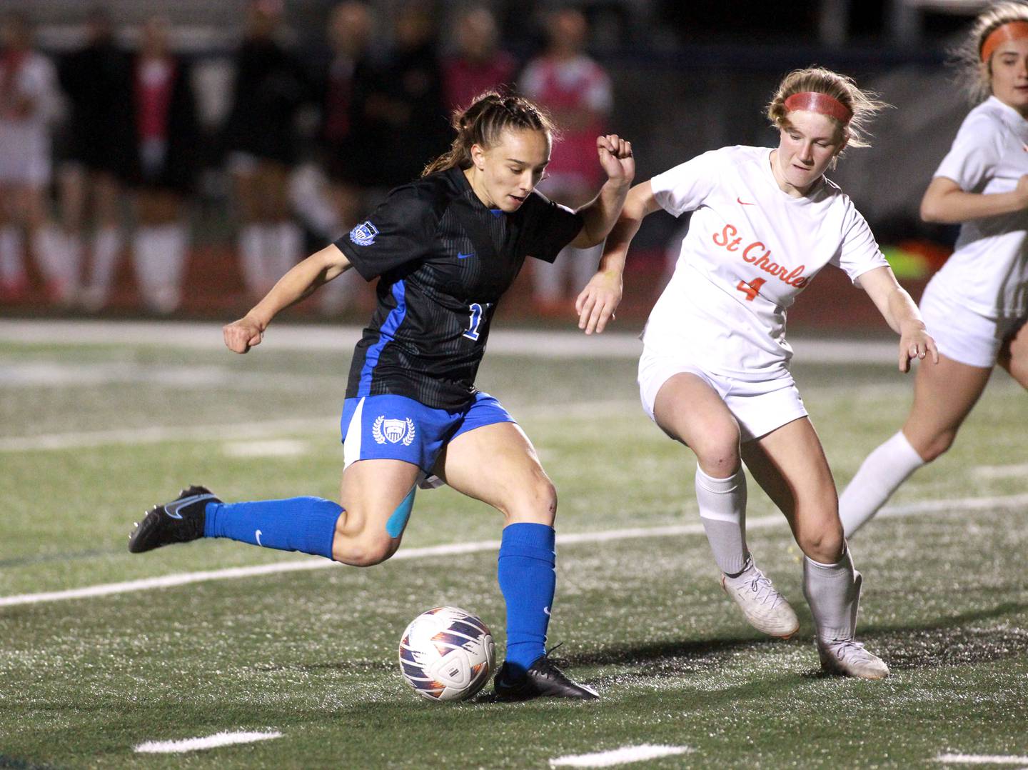 St. Charles North’s Laney Stark attempts a shot on goal past St. Charles East’s Presley Kannaka (right) during a Tri-Cities Night game at St. Charles North on Tuesday, April 23, 2024.