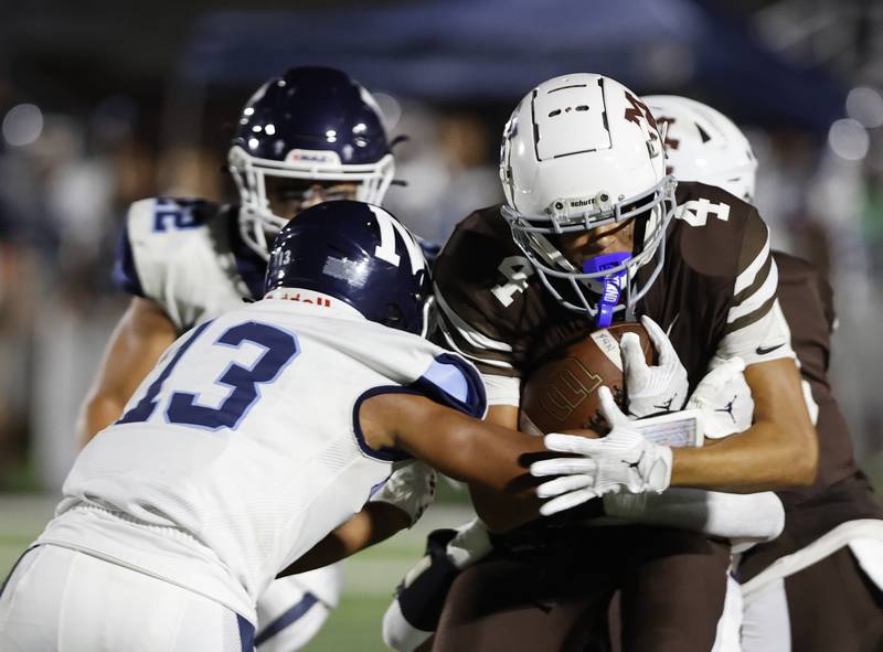 Nazareth's Yandiel Colon (13) attempts to stop Mt. Carmel's Quentin Burell (4) during the varsity football game between Nazareth Academy and Mt. Carmel high school on Friday, Sep. 13, 2024 in Chicago.