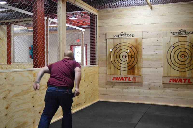 Chris Chapman throws two axes during the grand opening of Rustic Ridge Axe Throwing on May 28. Chapman is the manager; his wife, Cassandra Chapman, is the owner. The business is located at 117 N. 4th St., Oregon, and is affiliated with the World Axe Throwing League.