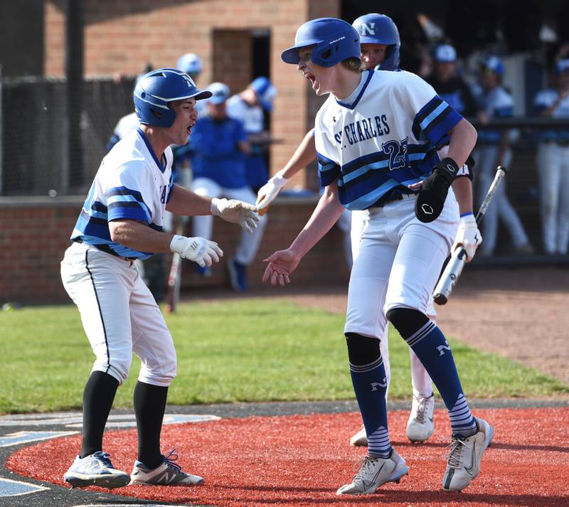 St. Charles North's Brad Lins, left, and Keaton Reinke celebrate scoring two runs against Lake Park during Friday’s baseball game in St. Charles.