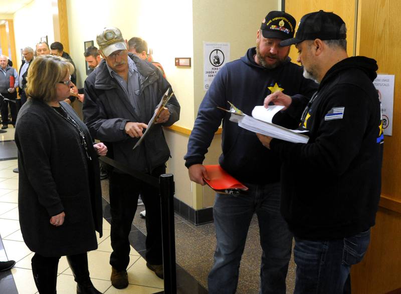 McHenry County Clerk Chief Deputy Debra Nieto helps McHenry County Board District 6 candidate Carl Kamienski with his paperwork as he waits to file his candidate forms the morning of Monday, March, 7, 2022, at the McHenry County Clerk's Office in Woodstock. Monday was the first day for candidates to file ahead of the June primaries. This election season includes all McHenry County Board seats, the clerk, sheriff and regional superintendent of education. The candidates were trying to get the first slot on the ballot by filling at 8 a.m. When more than one candidate applies at a time, a lottery is held.