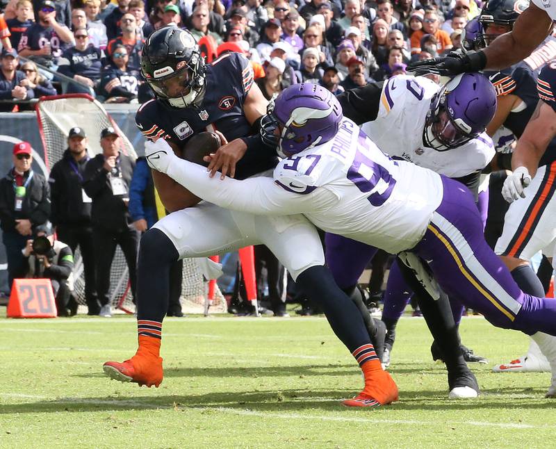 Chicago Bears quarterback Justin Fields is brought down by Minnesota Vikings defensive lineman Harrison Phillips during a run on Sunday, Oct. 15, 2023 at Soldier Field.