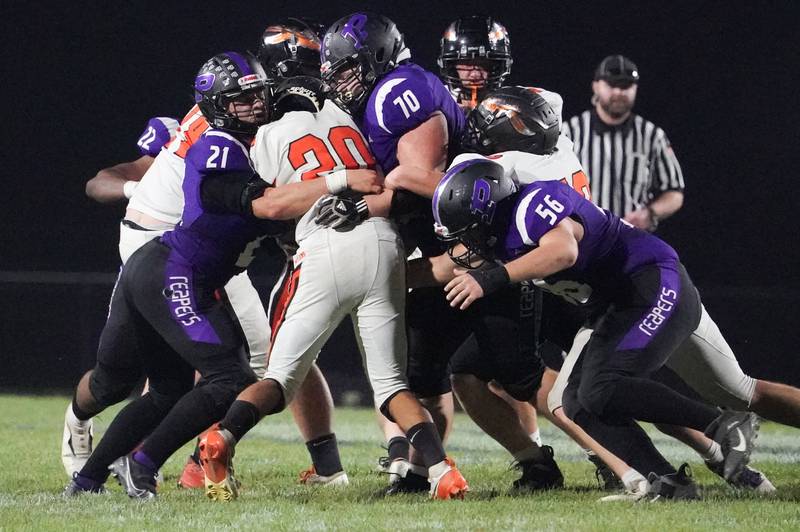 Plano's Kolten Schimandle (21), Tyler Mast (70) and PRider Larson (56) tackle Sandwich’s Diego Gomez (20) in the backfield for a loss during a football game at Plano High School on Friday, Sep 13, 2024.