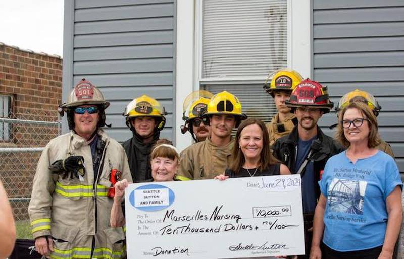 The Marseilles Fire Department, Seattle Sutton, along with her daughter Sarah (Sutton) Borgstrom and Marseilles Nursing Service representative Kathy Rosengren, RN, pose for a donation from the family of Dr. H.K. Sutton on Tuesday, July 2, 2024.
