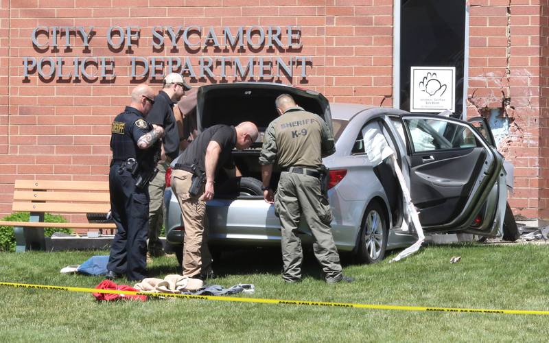Law enforcement from several agencies search a car after it was cleared by a remote controlled vehicle and officers in protective gear Wednesday May 26, 2021 at the Sycamore Police Department. The car crashed into the Sycamore Police Department building near the front entrance on DeKalb Avenue.