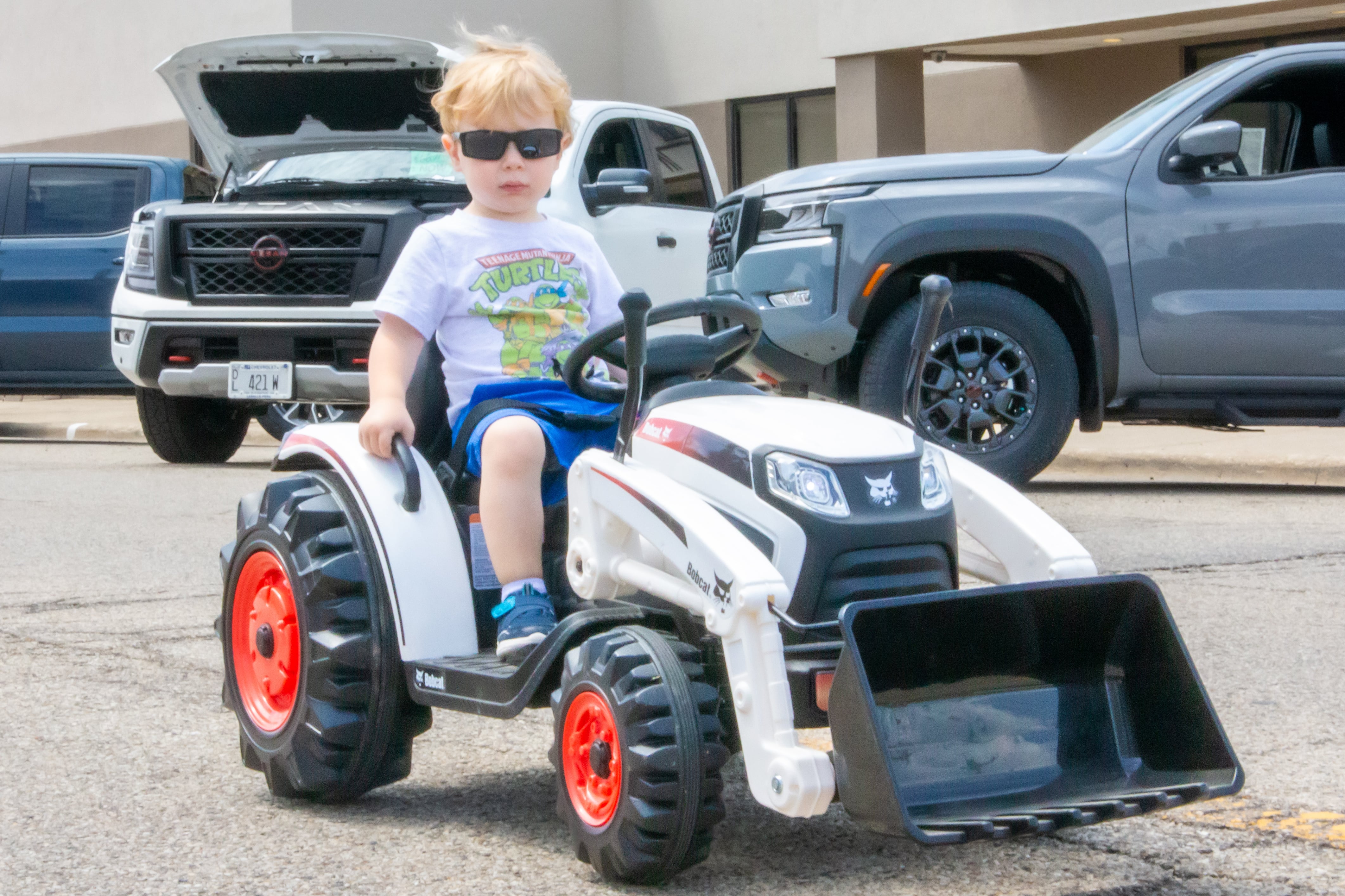 Mack Scholle drives toy tractor on Saturday, July 20, 2024 at the Convoy Against Cancer Big Truck Show on Main Avenue in Ladd.