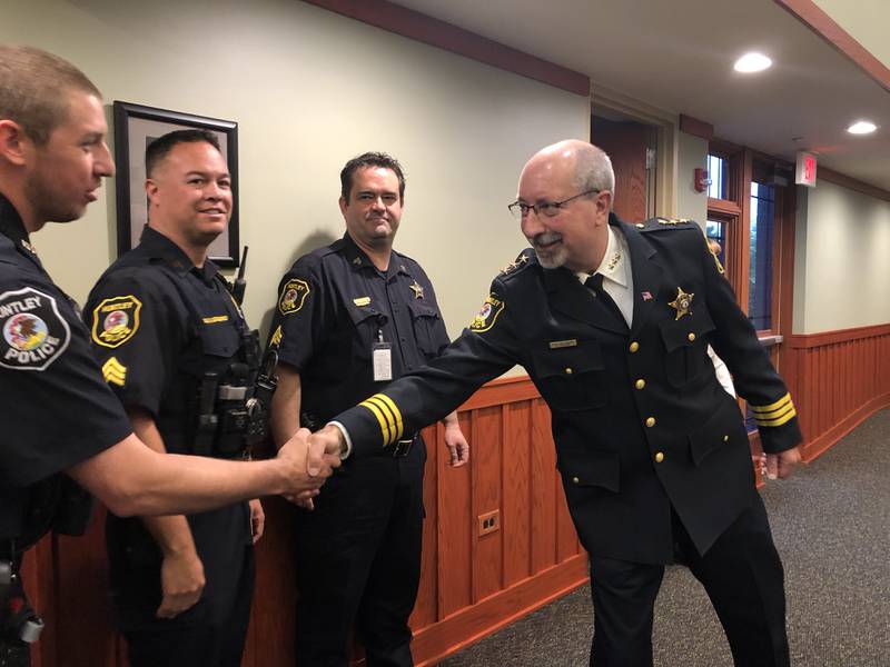 Huntley police chief Robert Porter shakes hands with Huntley police officers May 23. 2024.