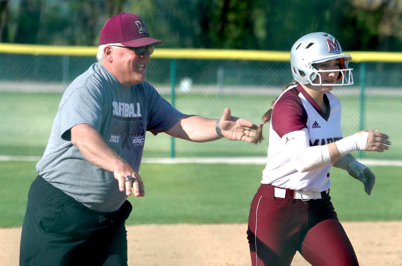 Marengo’s third base coach Rob Jasinski sends Gabby Christopher home on a home run against Richmond-Burtonin  varsity softball at Marengo Monday.