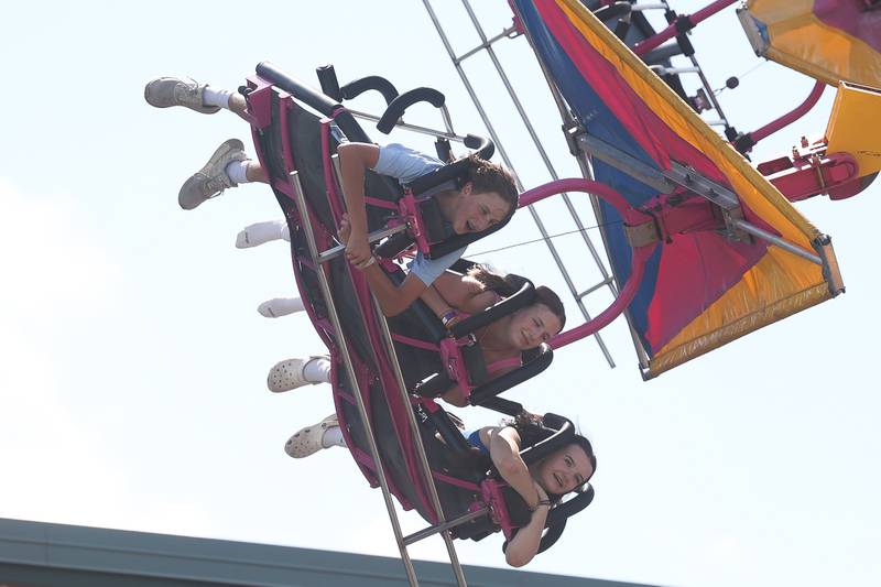 A group of teens ride the Cliff Hanger at Plainfield Fest on Saturday June 29, 2024.