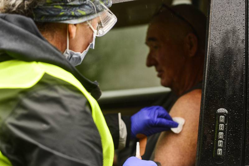 FILE - Registered nurse Megan Chamberlain gives a flu shot to Anthony Devitt, of Marlboro, Vt., during a flu vaccine clinic on Route 9, in Brattleboro, Vt., that was hosted by Visiting Nurse and Hospice for Vermont and New Hampshire on Tuesday, Oct. 26, 2021. (Kristopher Radder/The Brattleboro Reformer via AP, File)