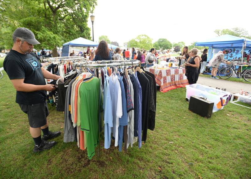 Jorge Ramos of Berwyn looks at t-shirts for sale during the Berwyn Garage Sale held Saturday July 8, 2023.